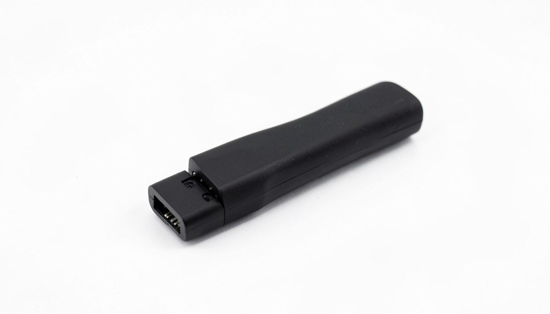 Mali crni AnyCast uređaj u obliku sticka s HDMI priključkom, na bijeloj podlozi